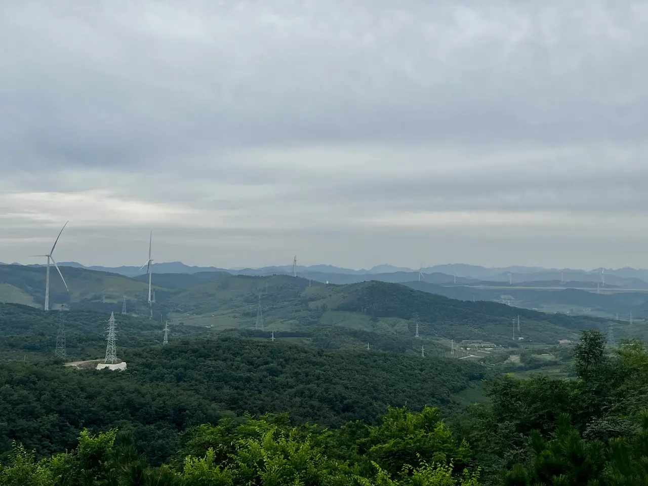 Wind turbines across a green mountain landscape